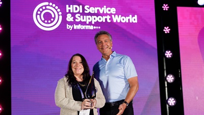 Cheryl Buzikcy of Infinite Campus on stage at HDI's Service & Support World accepting the trophy for her 2026 win for Best Service & Support Analyst