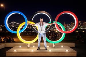 a man standing in front of the Olympics rings